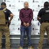Hombre detenido con dos custodios a los lados