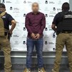 Hombre detenido con dos custodios a los lados