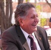 Presidente municipal de Zapopan, Juan José Frangie sonriendo mientras está sentado al lado de una mujer durante un evento público