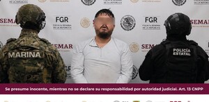 Gilberto ‘N’ con los ojos censurados con blur siendo detenido en medio de militar de la Marina y policía del Estado de Colima