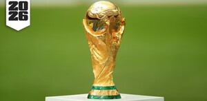 El trofeo de la Copa Mundial de la FIFA sobre una base blanca y al fondo una cancha de fútbol