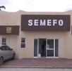 Se observa una fachada color beige con letras que dicen Semefo.
