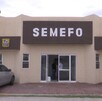 Se observa una fachada color beige con letras que dicen Semefo.