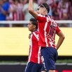 Ricardo Marín, futbolista de las Chivas del Guadalajara levantando el puño con otros jugadores caminando desenfocados en el fondo en el Estadio Akron