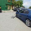 Se observan unos carros y unas personas de pie en la víc pública.