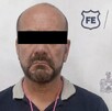 Se observa a un hombre con ojos tapados, con playera y pantalón de mezclilla.