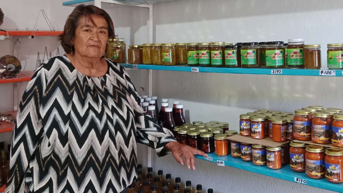 Emprendedora y artesana de Teotihuacán frente a un estante con productos artesanales a base de xoconostle