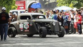 personas observan un auto clásico de la carrera panamericana en el centro de tehuacán