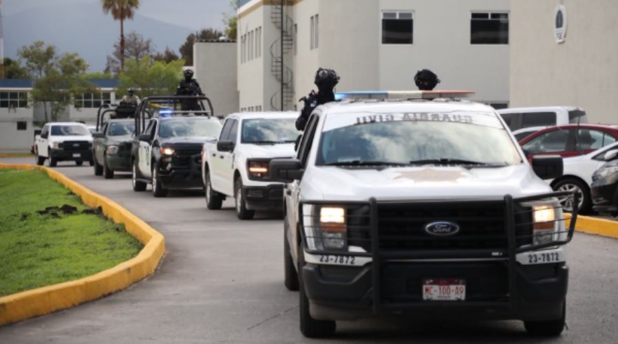 Patrullas de la Guardia Civil y de la Policía de Michoacán circulando en fila hacia la salida del Fiscalía del Estado
