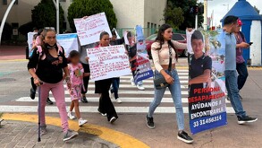 Mujeres y hombres marchando en un cruce peatonal con pancartas y fichas de búsqueda del menor desaparecido Jeremi Villegas en Tonalá