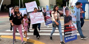 Mujeres y hombres marchando en un cruce peatonal con pancartas y fichas de búsqueda del menor desaparecido Jeremi Villegas en Tonalá