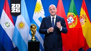 Gianni Infantino posando con las banderas de los países anfitriones de la Copa del Mundo 2030.