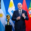 Gianni Infantino posando con las banderas de los países anfitriones de la Copa del Mundo 2030.