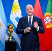 Gianni Infantino posando con las banderas de los países anfitriones de la Copa del Mundo 2030.
