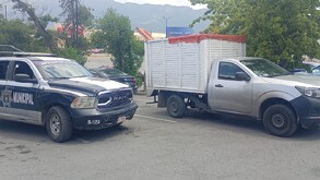 Se observan unos vehículos estacionados.