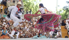 Un hombre y una mujer realizando un baile durante la Guelaguetza 2026.