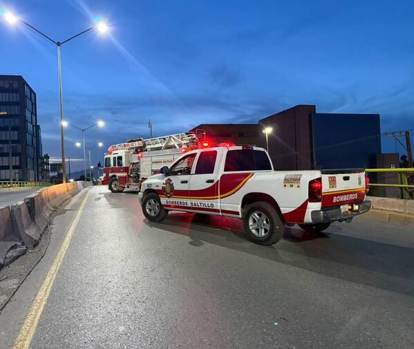 Se observan unos camiones estacionados en un puente vehicular.