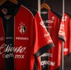 Playeras de los jugadores del Atlas FC colgadas en ganchos dentro de los vestidores del equipo en el Estadio Jalisco