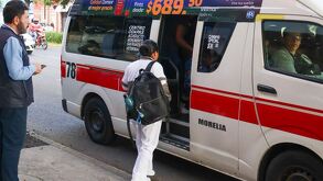 Una enfermera vista de espaldas a punto de ingresar a una combi del transporte público en Morelia, Michoacán con las puertas abiertas