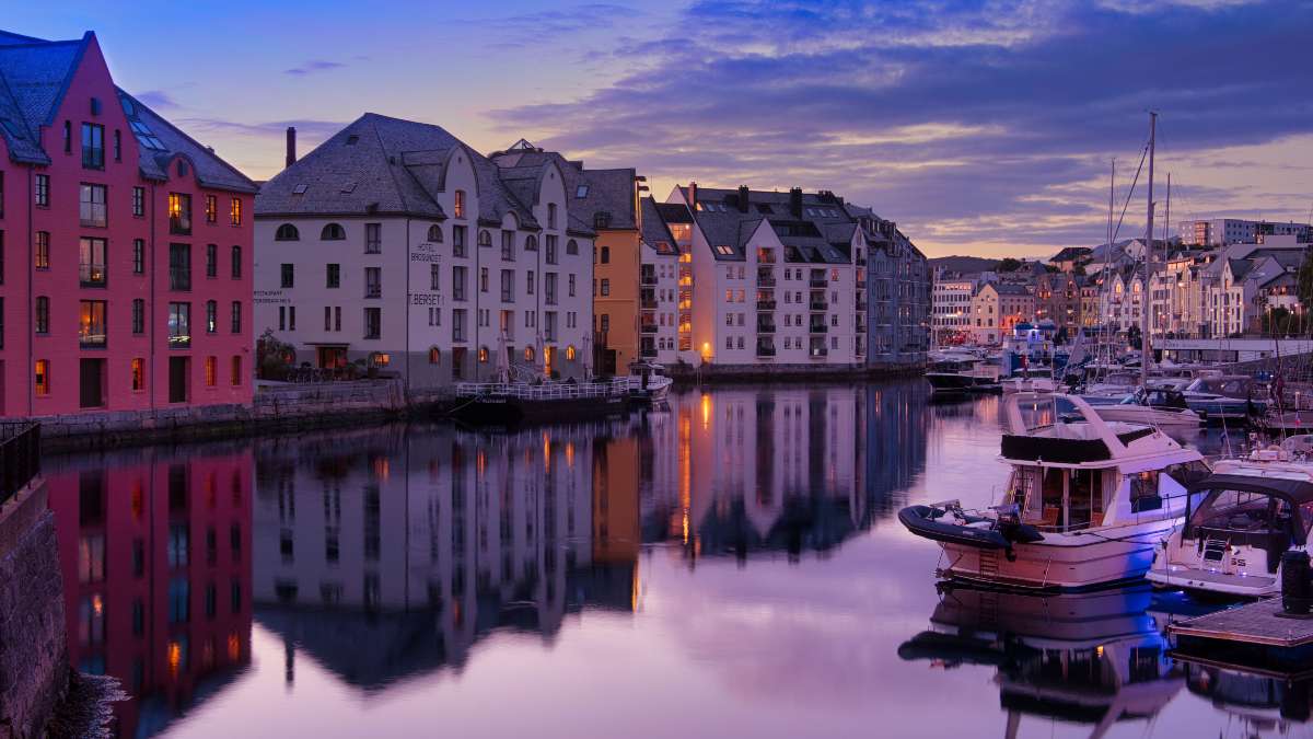 Un puerto de Noruega con casas y algunos barcos pequeños