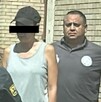 Se observa a una mujer que porta cachucha negra y tiene cintilla negra en ojos.