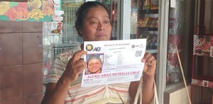 Mujer llorando con la foto de su hijo desaparecido en Escobedo.