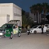 Se observa a varias personas caminando en la vía pública, es de noche.