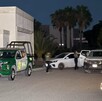 Se observa a varias personas caminando en la vía pública, es de noche.