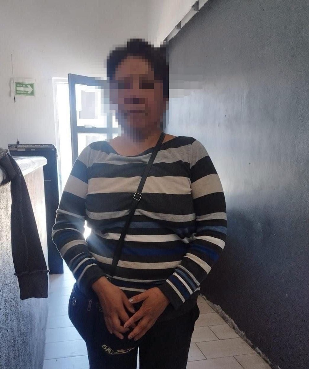 Mujer de edad adulta con una playera rayada y una bolsa cruzada.