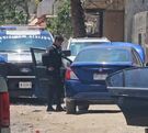 Patrulla de la Policía de Zapopan dentro de un área acordonada con autos estacionados detrás en un camino de tierra