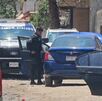 Patrulla de la Policía de Zapopan dentro de un área acordonada con autos estacionados detrás en un camino de tierra