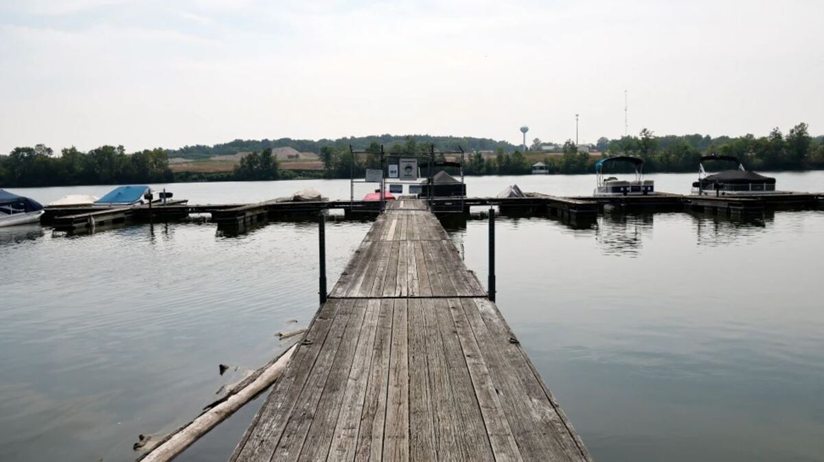 Una vista del muelle en el río Scioto con lanchas estacionadas y árbole y cerros vistos en el fondo