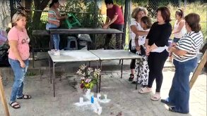 Mujeres rezando en el sitio donde asesinaron a un hombre momentos antes.