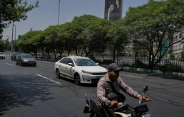 Vehículos enfrente de un cartel con el retrato del fallecido líder supremo iraní ayatolá Ali Jamenei, en Teherán, el 21 de julio del 2026.