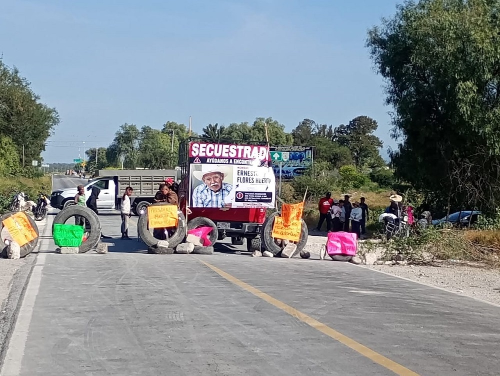 Personas bloqueando una carretera por la desaparición de un hombre.