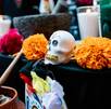 Una ofrenda de Dia de Muertos con una veladora y una calavera de azúcar