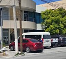 Se observan varios autos estacionados  y una vagoneta color blanca.