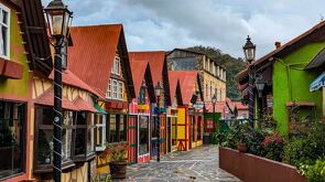 Casas con fachadas europeas y estéticas navideña con muchos colores, plantas alrededor y un cielo nublado en Tlalpujahua