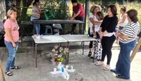 Mujeres rezando en el sitio donde asesinaron a un hombre momentos antes.