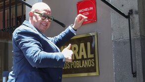 Hombre colocando una placa roja afuera de un restaurante en Puebla.