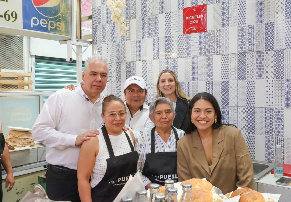 Personas sonriendo al interior de un puesto de cemitas en Puebla.