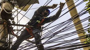 Hombre electricista trabajando en cables de alta tensión.