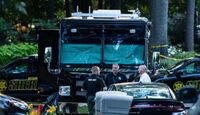 Camión y patrullas de la Policía de Michigan junto con policías y vehículos oficiales desplegados en una calle con árboles en el fondo