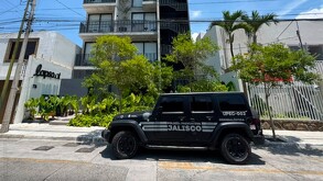 Camioneta blindada de la Policía de Jalisco estacionada al exterior de un edificio de departamentos en Guadalajara