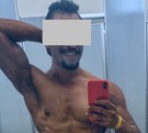Hombre musculoso posando para una selfie.