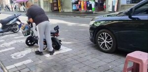 Hombre estacionando su motocicleta en un sitio de la vía pública en Puebla.