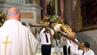 Se observa una escultura de Cristo y varios sacerdotes alrededor.