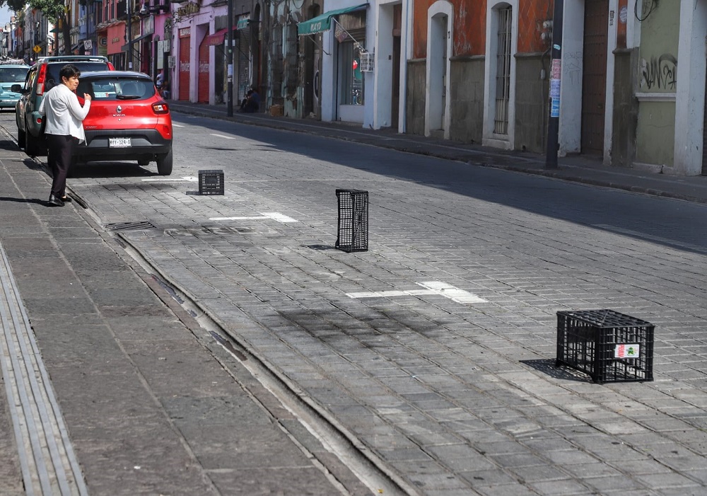 Objetos colocados en cajones de parquímetro en Puebla para impedir el paso de vehículos.