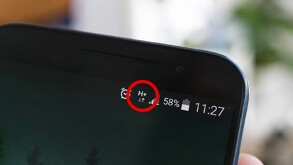 Vista de la esquina de una pantalla de un teléfono celular con el símbolo H+ encerrado en un círculo rojo en medio de símbolos de alarma y batería