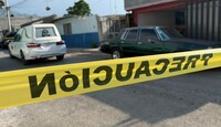 Se ven de fndo unos carros estacionados y una cinta amarilla de precaución.